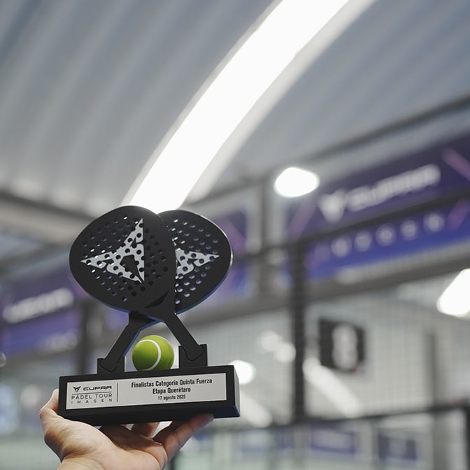 Two people standing between two parked CUPRA Terramar at twilight; a man on the right faces a woman on the left, who is standing near a dark green CUPRA Terramar and a wall-mounted charging station, while a purple Terramar is shown from the rear. 